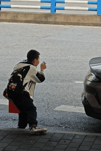 小米SU7成街头最靓的仔 吸引小学生用儿童手表拍照